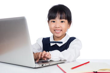 Asian Chinese little girl in uniform studying with laptop