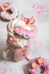 Pink strawberry freakshake milkshake with sweets donut and marshmallow