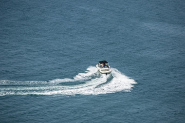 high speed motor boat with wave trail on the water. © Andy Shell