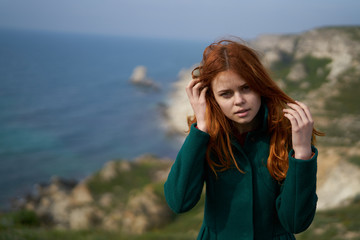 Young beautiful woman on the edge of a cliff near the sea