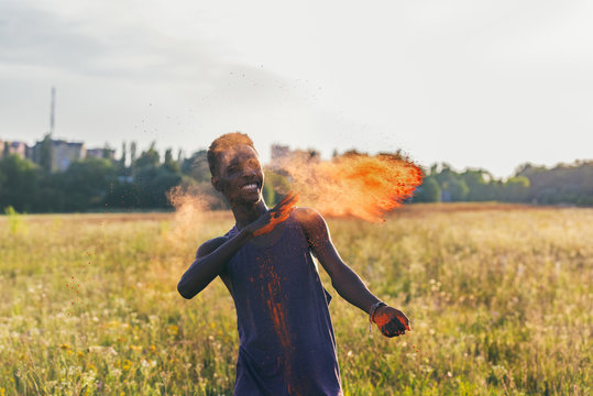 Portrait Of Happy African American Man Throwing Colorful Powder At Holi Festival