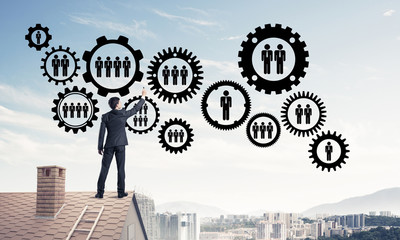 Businessman on house roof presenting teamwork and connection con