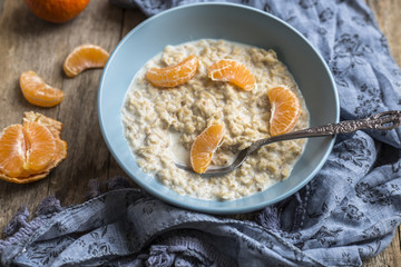 Healthy breakfast - oatmeal with slices of tangerines
