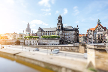Obraz premium View on the riverside of Elbe river with beautiful buildings and church dome during the sunny weather in Dresden city, Germany. Tilt-shift image technic