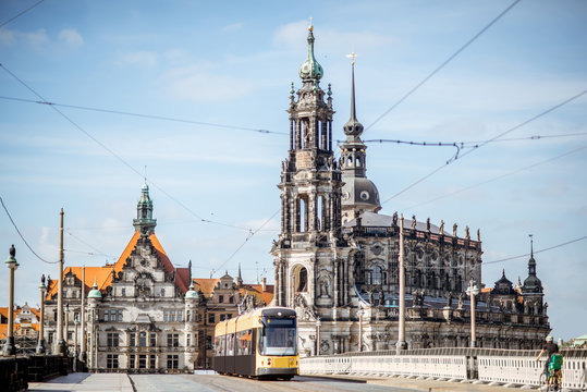 View on the riverside of Elbe river with catholic church, city gates and tram during the sunny weather in Dresden city, Germany