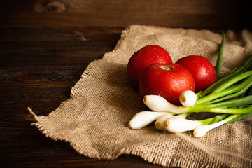 riped tomatoes and spring onions on a linen centerpiece