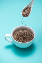 Cup of healthy chia seeds and spoon. Text space.