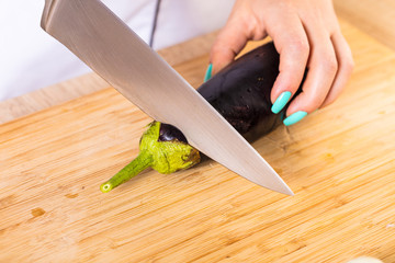 The cook cuts the eggplant