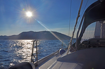 Fototapeta premium The view from the yacht to the island against sunlight
