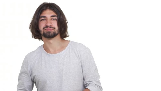 Longhaired Caucasian guy gesturing his thumb down isolated over white background. Concept of emotions