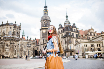 Obraz premium Young woman with photocamera walking on the Theaterplatz in Dresden, Germany