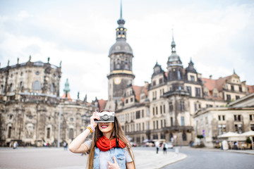 Young woman with photocamera walking on the Theaterplatz in Dresden, Germany