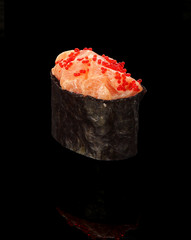 Japanese cuisine. Sushi gunkan over black background.