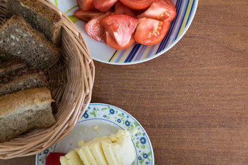 dairy products, tomatoes and bread on wooden table