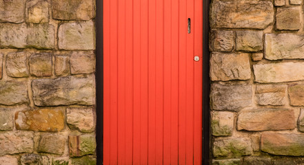 Bright red door set into sandstone wall