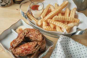 Deep fried chicken wing and french fries