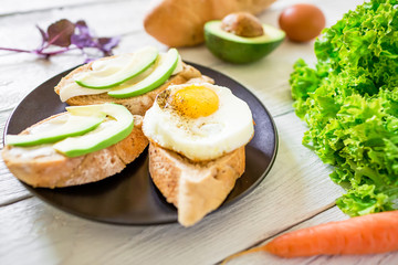 Sandwich with avocado and egg on white table. Fitness breakfast