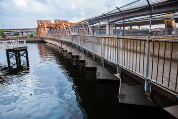 Walkway above water with train tracks running along it