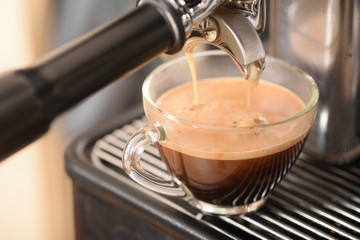 Coffee flowing into a cup from espresso machine