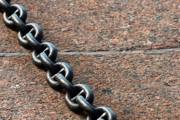 Heavy metal chain on granite stone floor