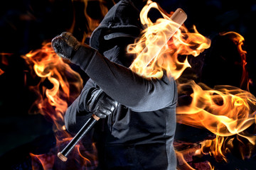 ein maskierter Mann hält einen Baseballschläger und ist von Feuer umgeben - obrazy, fototapety, plakaty
