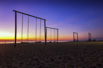 swing and beautiful tropical beach over magical twilight sunrise at dawn