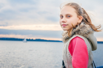 Child on the river in cloudy weather in the evening is on the ship.