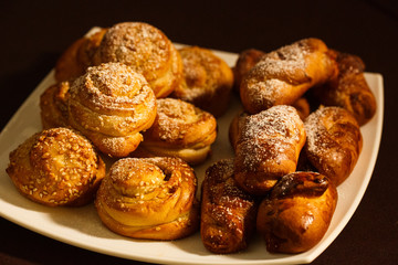 ruddy delicious muffins dusted with powdered sugar on the plate on brown tablecloth