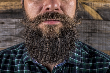 man beard and mustache over wooden background.Perfect beard
