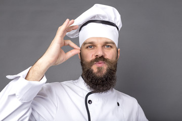 Studio shot of a bearded chef showing OK sign