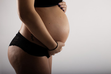 pregnant woman touching her belly with hands