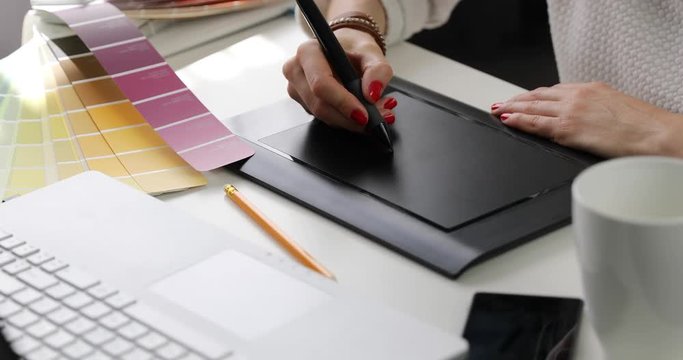 woman graphic designer using digital drawing tablet at advertising agency office