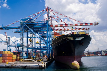 Cranes load a merchant ship in a commercial port terminal, Naples in Italy