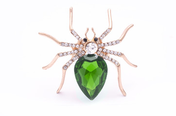 Golden spider with a big green stone isolated on white