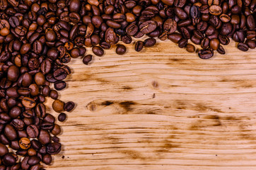 Pile of the roasted coffee beans on wooden table. Top view