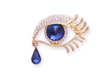 Gold brooch eye with diamonds аnd a large sapphire isolated on white