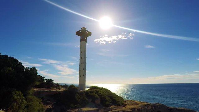 Modern lighthouse on the coast - sun rays 