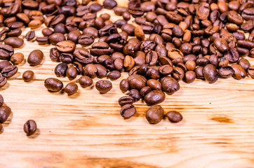 Pile of the roasted coffee beans on wooden table