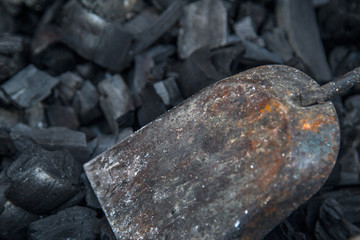 Embers. Ash in the barbecue grill and shovel for stirring the coals.