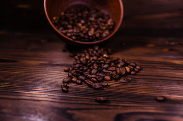 Roasted coffee beans in bowl on wooden table