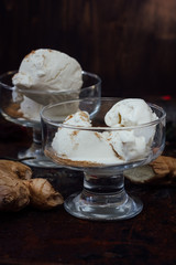 White ginger ice cream on transparent glass on black surface.