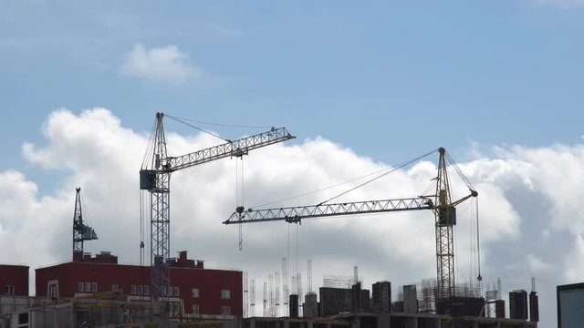 Construction site against a blue sky with floating clouds.