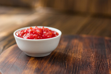 Indian chutney or mexican salsa in white ceramic bowl.