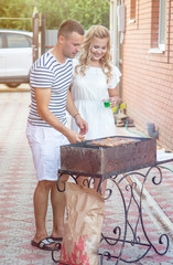 young happy couple cooking BBQ