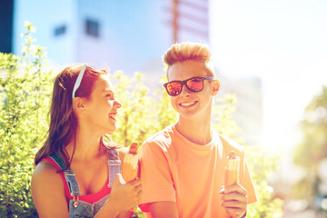 Fototapeta premium happy teenage couple eating hot dogs in city
