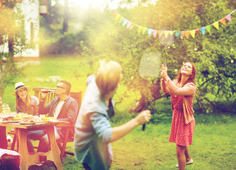 Fototapeta premium happy friends playing badminton at summer garden