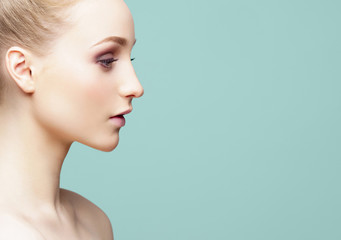 Fototapeta premium Beauty close-up portrait of beautiful, fresh and healthy girl over cyan background.
