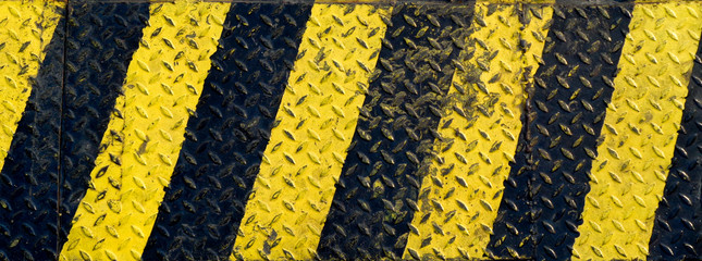 Black and yellow line paint on non-slip metal background