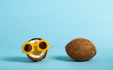 Fresh coconut wearing sunglasses on a bright blue background