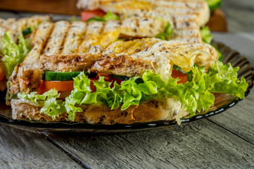 Panini sandwich with ham, tomato and lettuce.